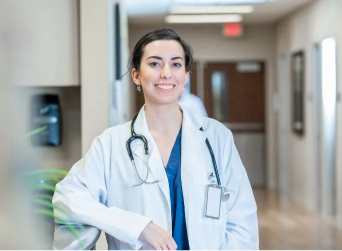 Smiling physician in a clinic hallway