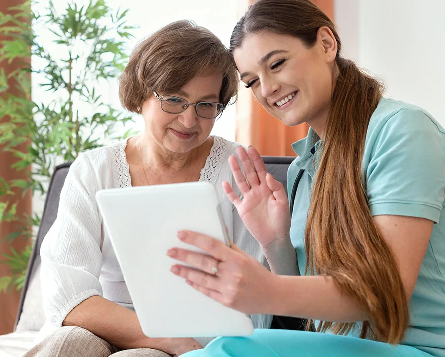 Care team member reviewing a tablet with an older patient